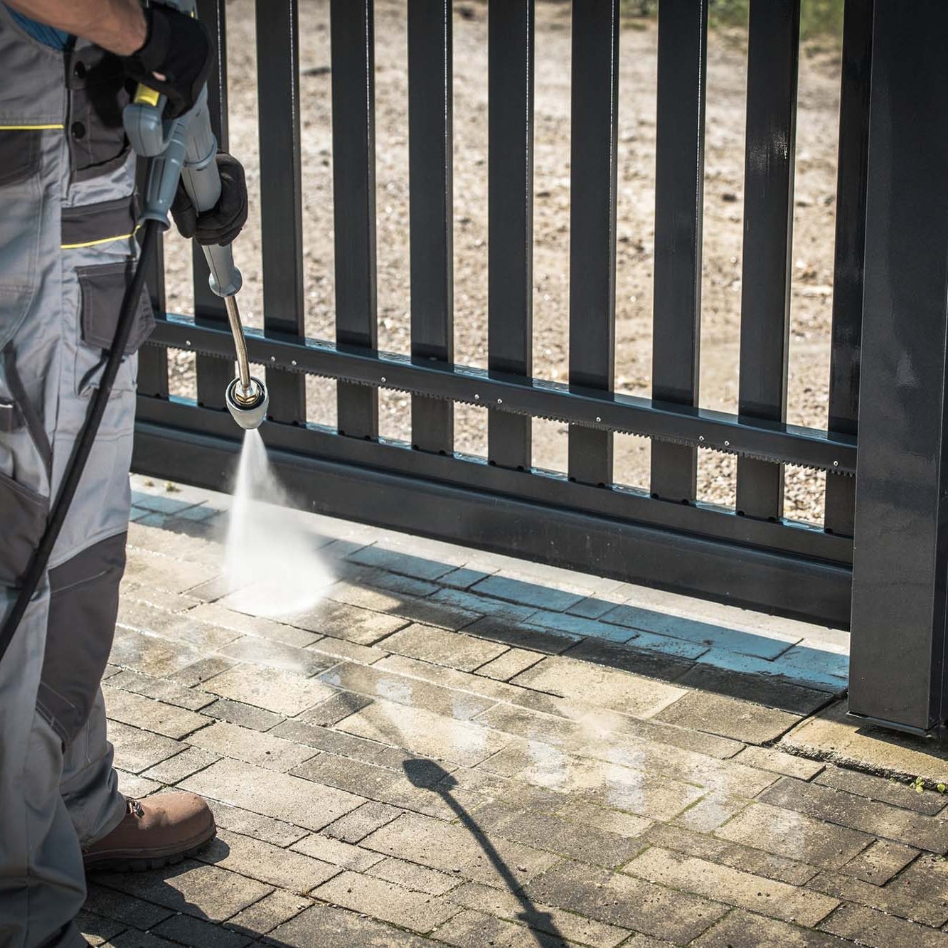 Power Washing Garden Cobble Stone Paths. Outdoor Cleaning Using Pressure Washer. Closeup Photo.